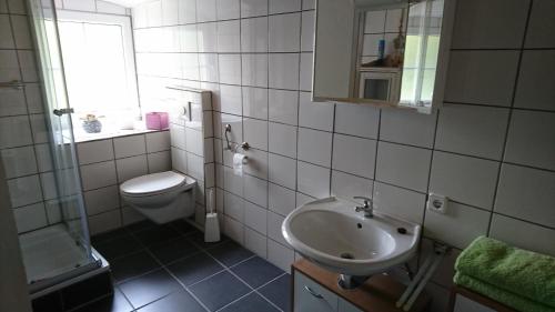 a white bathroom with a sink and a toilet at Ferienwohnung in Solnhofen mit Terrasse, Garten und Grill - b48667 in Solnhofen