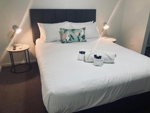 a bed with two towels and two lamps on it at The Platypus Accommodation & Cafe in Cudal