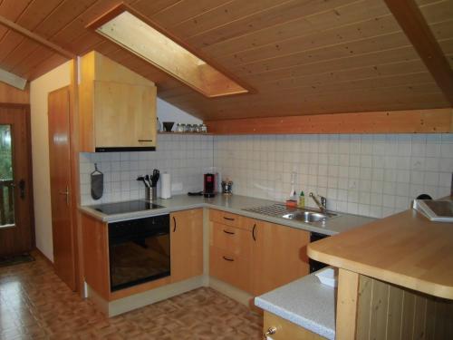 cocina con fregadero y fogones horno superior en Ferienwohnung Nägeliplatten - b48644, en Hasliberg