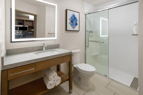 y baño con aseo, lavabo y ducha. en Candlewood Suites Richmond - South, an IHG Hotel, en Richmond