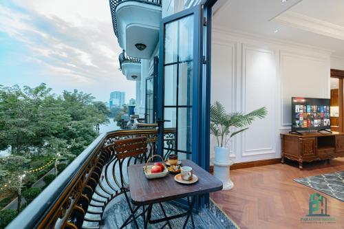 a balcony with a table and a view of a river at Luxe Paradise Suite Hotel Trich Sai in Hanoi
