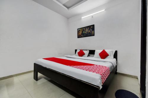 a bedroom with a bed with red pillows at OYO Hotel Real Residency in Jodhpur