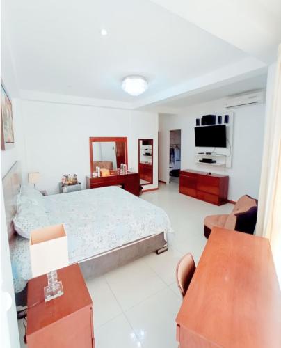 a bedroom with a bed and a flat screen tv at Deluxe Hotel Talara in Talara