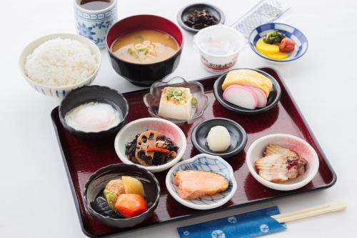 un plateau rempli de différents types de nourriture sur une table dans l'établissement APA Hotel Midosuji Hommachi Ekimae, à Osaka