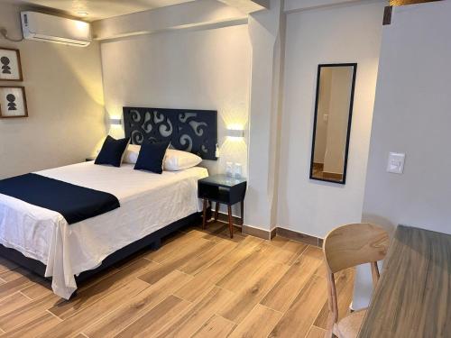a bedroom with a bed and a table and a mirror at Centrico House in Taxco de Alarcón