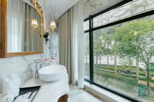 a bathroom with a sink and a large window at Luxe Paradise Suite Hotel Trich Sai in Hanoi