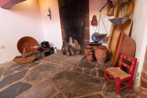 a room with a stone floor with vases and a fireplace at Monte Farropo in Monsaraz