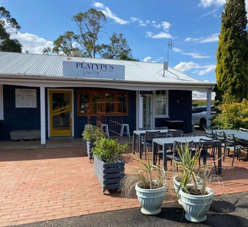 a restaurant with tables and chairs in front of it at The Platypus Accommodation & Cafe in Cudal