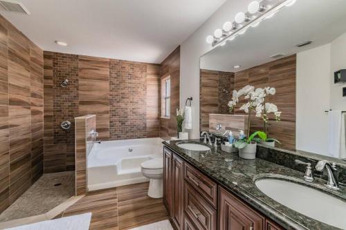 a bathroom with a tub and a toilet and a sink at (HGR) Poolside Paradise: Vacation retreat. (Heated Pool) in Tampa