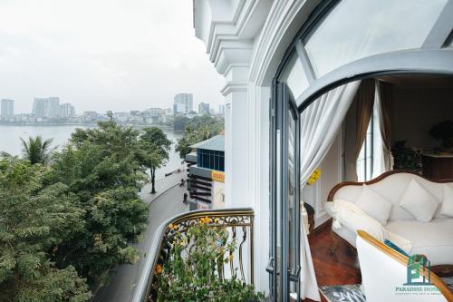 a balcony with a couch and a view of the water at Luxe Paradise Suite Hotel Trich Sai in Hanoi