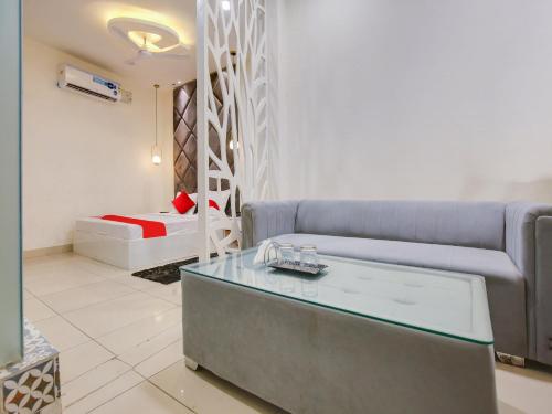 ein Wohnzimmer mit einem Sofa und einem Bett in der Unterkunft Super OYO Hotel Orchid Regency in Ludhiana