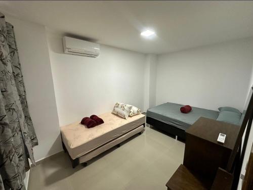 a small room with two beds and a air conditioner at Aconchegante apt de 2 dormitorios in Rio de Janeiro