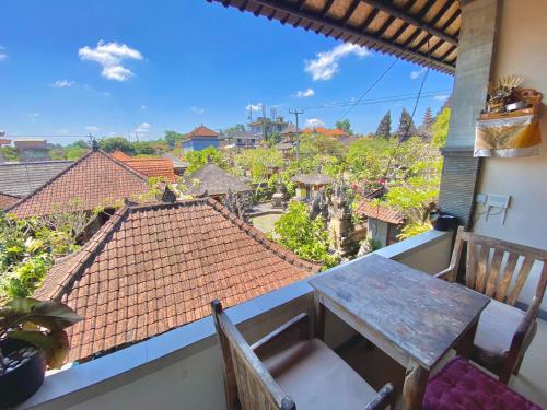 einen Tisch und Stühle auf einem Balkon mit Aussicht in der Unterkunft Wina Ubud B&B in Ubud