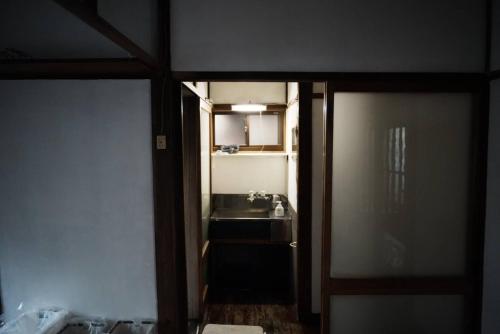 eine offene Tür zu einem Bad mit einem Waschbecken in der Unterkunft CASA DE YOSHI MIHATACHOU 一棟貸 in Yamagata