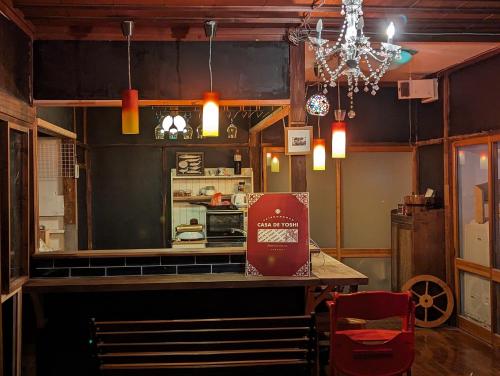 a kitchen with a counter and a table with a sign at CASA DE YOSHI MIHATACHOU 一棟貸 in Yamagata