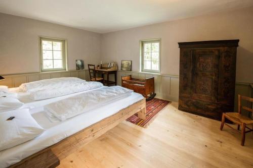 a bedroom with a large bed and a wooden floor at Bahnwärterhaus Eggwald - b48797 in Wassen