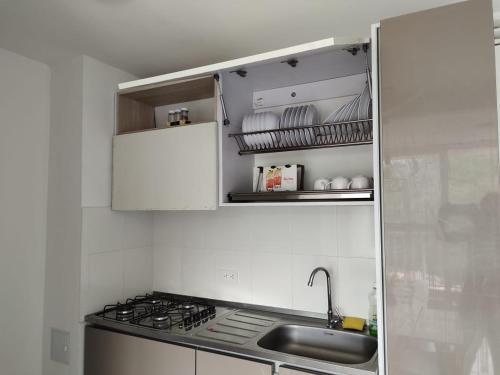 a white kitchen with a sink and a stove at Apartamento en entorno natural in Villeta