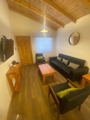ein Wohnzimmer mit einem Sofa und einem Tisch in der Unterkunft Cabañas loretito playa Chica Lican Ray in Licán Ray
