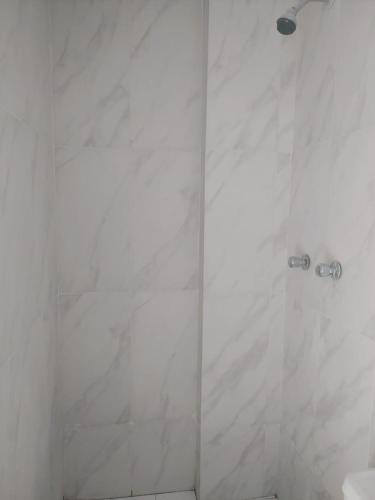 a bathroom with a shower with white marble walls at Nuestro Señor del Camino in Cajamarca
