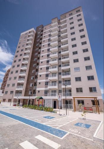 um grande edifício de apartamentos com um parque de estacionamento em frente em Quarto Privado em Aracaju