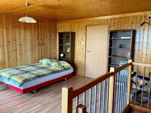 1 dormitorio con 1 cama en una habitación de madera en La Ferme - b48766, 