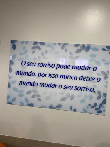 a sign on a white wall with a writing on it at Quarto Privado in Aracaju