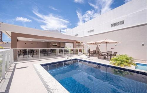 a swimming pool next to a building with a house at Quarto Privado in Aracaju