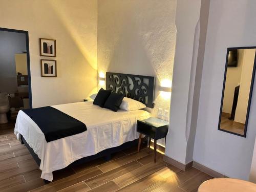 a bedroom with a bed with a black and white blanket at Centrico House in Taxco de Alarcón