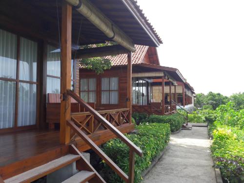 a wooden house with a porch and stairs to it at Marind Dive Eco Resort in Waha