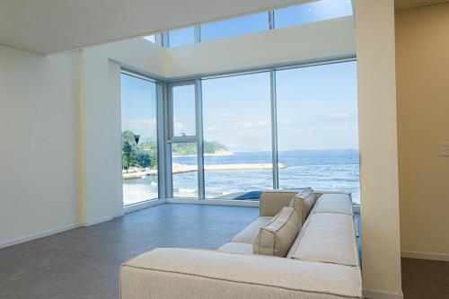 a living room with a couch and a view of the ocean at OOU SPACE in Geoje