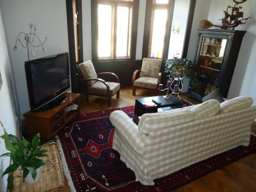 een woonkamer met twee witte stoelen en een televisie bij Wohnung in Hernals mit Garten - b48752 in Wenen