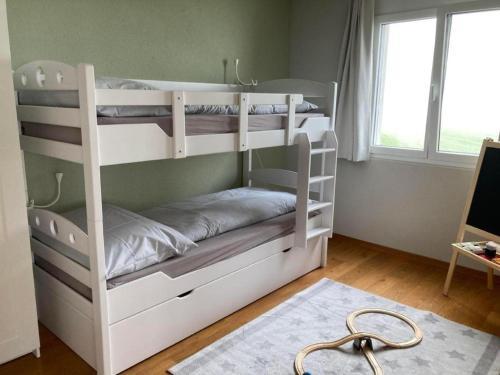 a white bunk bed in a room with a window at Ferienwohnung Seehof - b48779 in Rorschacherberg