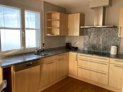 a kitchen with wooden cabinets and a sink at Ferienwohnung Seehof - b48779 in Rorschacherberg