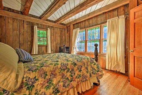a bedroom with a bed in a room with wooden walls at Bear's Eye View - Mountain Retreat w/ Hot Tub! in Acme