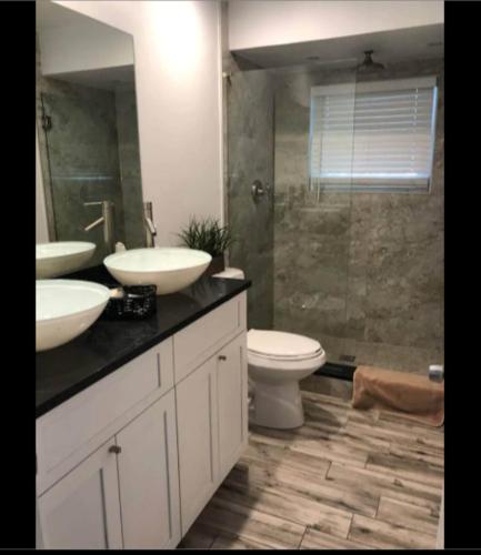 a bathroom with two sinks and a toilet and a shower at Keese's Cottages in Fort Lauderdale