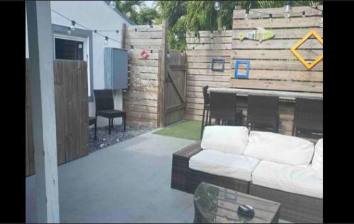 a backyard with a couch and a wooden fence at Keese's Cottages in Fort Lauderdale
