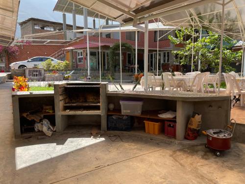Hospedaje Villa Justina في سانتا يولاليا: طاولة خرسانية أمام مبنى به كراسي