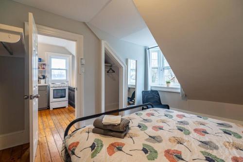 a bedroom with a bed with a quilt on it at Sunny Loft #4, Historic Home in Halifax