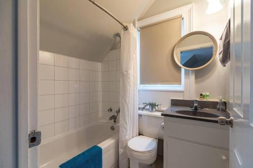 La salle de bains est pourvue d'un lavabo, de toilettes et d'un miroir. dans l'établissement Sunny Loft #4, Historic Home, à Halifax