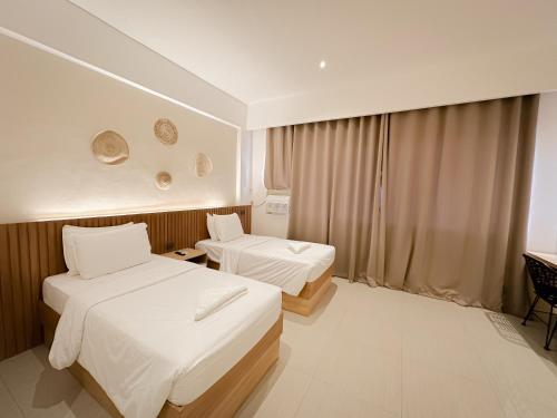 Habitación de hotel con 2 camas y escritorio en LEUX Hotel Alona Panglao, en Panglao