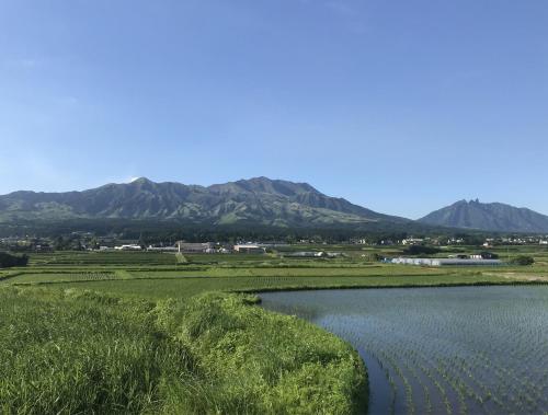 a body of water with mountains in the background at Ryokoji Temple in Minami Aso