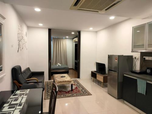 a kitchen and living room with a refrigerator and a table at Taragon Suits Apartment KL in Kuala Lumpur
