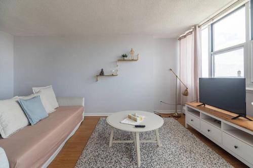 a living room with a couch and a tv and a table at Bright DT Apt #7A, Amazing View in Halifax