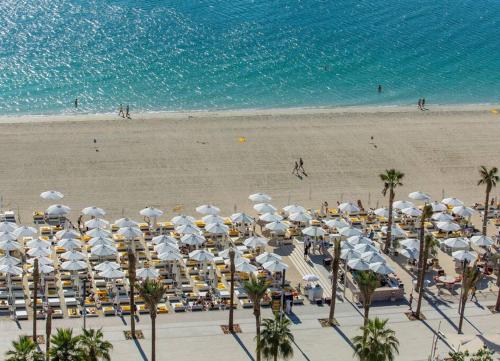 a beach with white umbrellas and chairs and the ocean at *Five Palm* 2bdr Private Beach in Dubai
