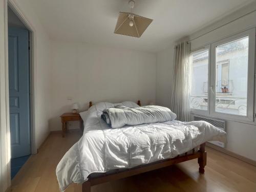 une chambre blanche avec un lit et une fenêtre dans l'établissement Maison moderne 3 chambres à 250m de la plage et des commerces, Les Sables-d'Olonne - FR-1-197-589, à Les Sables-dʼOlonne