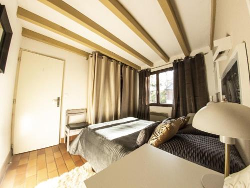 ein Schlafzimmer mit einem Bett und einem Tisch mit einer Lampe in der Unterkunft Maison moderne et traditionnelle à 300m de la plage, avec jardin, barbecue et parking privé - FR-1-413-234 in Capbreton