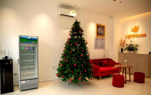 een kerstboom in een woonkamer met een rode stoel bij Light House Motel 978 in Long Hai
