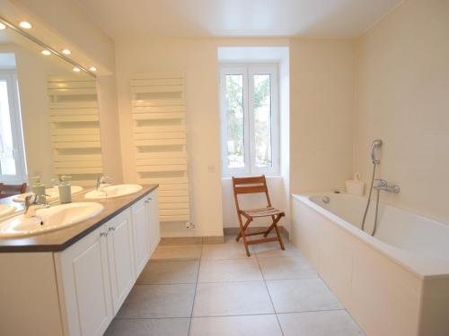 a bathroom with two sinks and a tub and a chair at Maison Lugrin, 7 pièces, 12 personnes - FR-1-498-100 in Lugrin