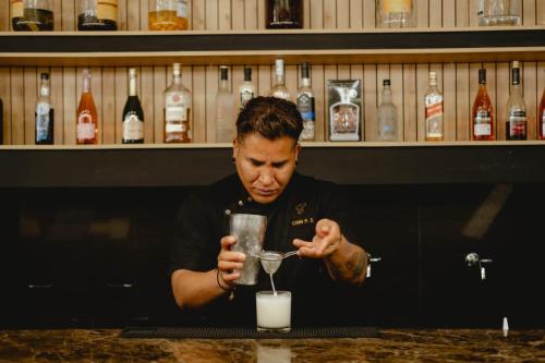 um homem sentado num bar com uma bebida em PRANA em Huancayo