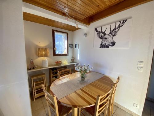 une salle à manger avec une table et une tête de cerf sur le mur dans l'établissement Les Angles - T4 Duplex 3 chambres - 6 pers, Parking, prox. commodités - FR-1-758-19, aux Angles